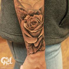 a woman's arm with a rose tattoo on it