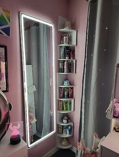 a pink room with a mirror, shelf and other items on the floor in front of it