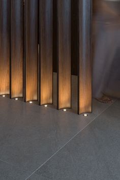 a room divider with three lights on each side and two people standing in the background