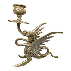 a brass figurine with a bird holding a candle in it's hand