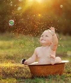 a baby sitting in a bathtub with soap bubbles