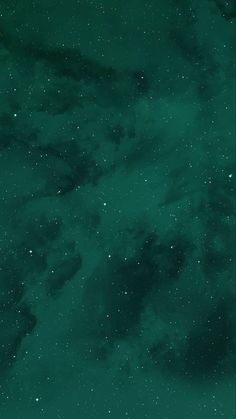 the night sky is filled with stars and dark green hues, as well as white clouds