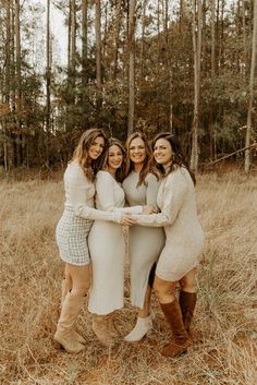 three women standing together in the woods with their arms around each other