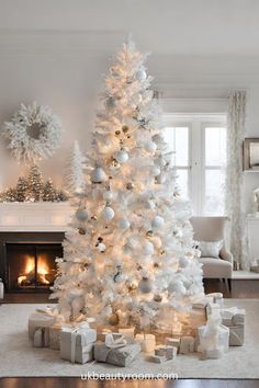 a white christmas tree with presents under it