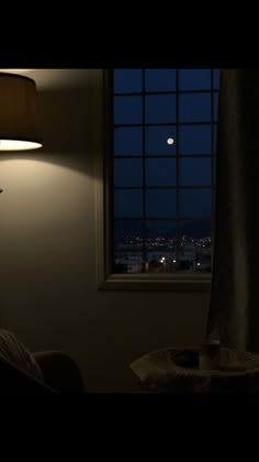 a bedroom with a window, lamp and view of the city