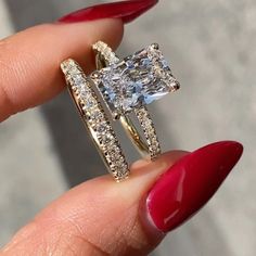 a woman's hand holding an engagement ring with two rows of diamonds on it