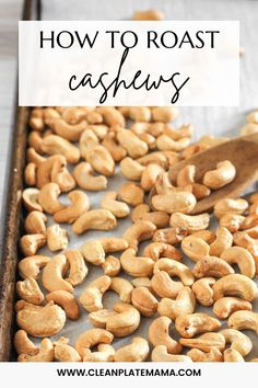 roasted cashews on a baking sheet with a wooden spoon and title overlay reads how to roast cashews