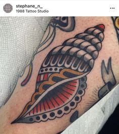 a close up of a person's arm with a tattoo on it and an object in the background