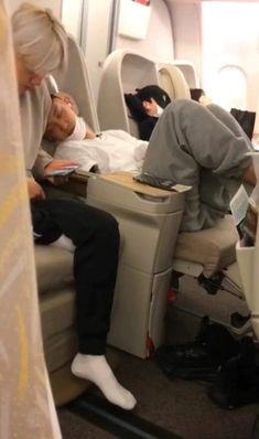 two people sleeping on an airplane next to each other