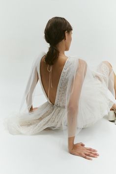 a woman in a white dress sitting on the ground