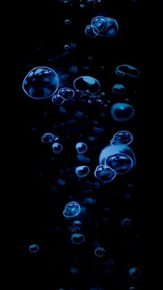 some bubbles floating in the air on a black background