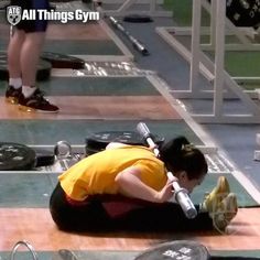 a woman kneeling on the ground with a gym equipment