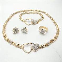 "18k Gold Filled Cubic Zirconia Double Hearts with XoXo Hug and Kisses Shape Set - Set Size: Necklace and Bracelet Thickness: 6mm | Necklace and Bracelet Heart Width: 22mm | Ring Size: 9 | Ring Width: 14mm | Earrings Height: 15mm | Earrings Width: 16mm | Necklace Length: 18 inches | Bracelet Length: 8 inches 💎 With new products daily, quality and competitive prices, in DiJu Jewelry you find the most unique styles of modern designs, always looking for elegance and market trends. *Helping your Je Gold Cubic Zirconia Jewelry Set For Valentine's Day, Gold Heart-shaped Jewelry Sets For Party, Heart-shaped Gold Jewelry Sets For Parties, Gold Jewelry Sets With Rhinestones As Gifts, Gold Jewelry Sets For Valentine's Day, Gold Jewelry Sets For Valentine's Day Party, Gold Rhinestone Jewelry Sets For Anniversary, Gold Jewelry Sets With Diamond Accents For Anniversary, Heart-shaped Cubic Zirconia Jewelry Sets For Valentine's Day