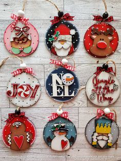 christmas ornaments are hanging on a wooden wall with the words noel written in different languages