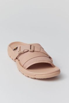 Teva's slide sandal with soft molded topsole and rugged outsole for varied terrain. Adjustable hook and loop straps offer a customizable fit while supportive + structured build is perfect for long walks or hikes. Content + Care. Rubber Spot clean Imported