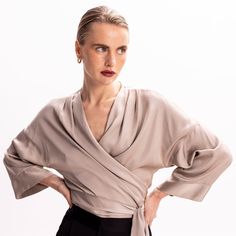 Easy and versatile, this blouse is crafted from high quality viscose fabric and has wide kimono sleeves. It is designed to wrap & tie in different ways. Wrap it around the waist and tie the straps at the front side, for a more classic look. Or cross the straps in the middle front (semi-tie, braided) and then wrap them around the waist and tie them either on the back or the front.  Pair it with its coordinating bias-cut skirt from the collection.   All pieces are cut one by one for an impeccable Chic Tops With Tie Waist And Surplice Neckline, Spring Evening Wrap Blouse, Silk Tops With Draped Sleeves For Work, Silk Top With Draped Sleeves For Work, Silk Wrap Blouse For Evening, Elegant Wrap Top With Surplice Neckline For Work, Silk Evening Wrap Blouse, Elegant Faux Wrap Blouse For Spring, Spring Season Formal Wrap Blouse