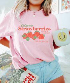 "🌟 Thank you for stopping by GirlyThreadsCo! This hand drawn coquette strawberry shirt is made to order just for you! This is the perfect tee for strawberry lovers, coquette fans,  and makes a great gift for trendy fashion lovers! 👕 PRODUCT & DESCRIPTION Our Comfort Colors 1717 t-shirts are pure comfort and garment dyed for that vintage look. Because they are unisex, they may be a bit loose on some ladies, or more fitted for some men, depending on body type and preference of fit. Our tops do have a loose fit but overall they are true to size. Please be sure to check the sizing chart to choose the right size for your preferred fit. 🚛 SHIPPING AND PRODUCTION TIME 6-9 days is needed for shipping and handling within the US. 10-30 days is needed for shipping and handling to Canada and the re Cute Pink T-shirt With Strawberry Print, Pink Fruit Print Tops For Spring, Spring Pink Tops With Fruit Print, Sweet Pink T-shirt With Strawberry Print, Cute Strawberry Print Tops For Spring, Sweet Pink Strawberry Print T-shirt, Vintage Fruit Print Crew Neck Tops, Vintage Summer Top With Fruit Print, Vintage Crew Neck Tops With Fruit Print