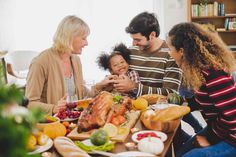 a group of people sitting around a table with food