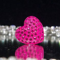 a pink heart shaped object sitting on top of a table