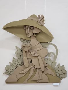 a paper cut out of a woman wearing a large hat