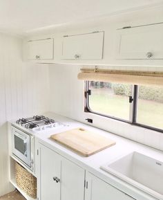 a kitchen with a sink, stove and window in it's sidewalls