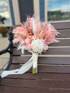 a bridal bouquet sitting on top of a wooden bench