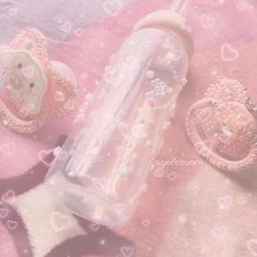 a pink and white teddy bear bottle next to a pacifier on a pink blanket