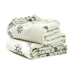 three blankets stacked on top of each other in white and black colors with an embroidered design