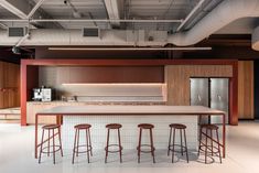 an empty kitchen with bar stools in the center and lots of counter space on the other side