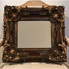 an ornate gold framed mirror sitting on top of a chair