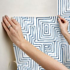 two hands on a piece of blue and white paper