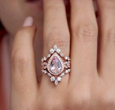 a woman's hand with a pink diamond ring on top of her left hand