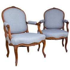 two chairs with blue upholstered seats and wood trimmings on the back