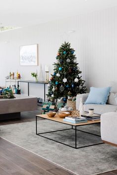 a living room filled with furniture and a christmas tree in the middle of the room