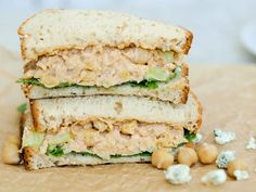 two sandwiches stacked on top of each other with chickpeas in the middle and one sandwich cut in half