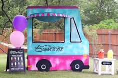 the ice cream truck is decorated with balloons and streamers for an outdoor birthday party