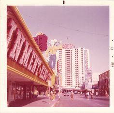 an old photo of people walking down the street in front of some hotels and motels