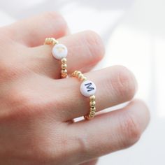 Beautiful beaded Ring with acrylic letters strung on an elastic cord. C U S T O M I N I T I A L ∙ R I N G ----------------------♡--------------------- M A T E R I A L S: * Ball: 18k Gold Plated over Brass * Beads gold: 3 mm * Letters: 7mm * It is made with stretchy elastic string that is very good quality!! -----------------------♡-------------------- SIZE * Adjustable Range US 6 - 8 - 9 ------------------------♡-------------------- H O W T O O R D E R 1.) Choose the Option in the drop down menu Trendy Round Jewelry With Letter Beads, Adjustable Initial Ring, Minimalist Jewelry With Letter Round Beads, Minimalist Jewelry With Round Letter Beads, Adjustable White Initial Ring As A Gift, Minimalist Letter Beads Jewelry For Friendship, Adjustable White Initial Ring Perfect For Gifts, Adjustable White Rings For Birthday, Minimalist Personalized White Initial Ring