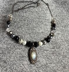 This necklace has been made using a vintage, darkened silver diamanté and faux Opal pendant, which has been threaded on to a silver plated wire bar, along with toning assorted beads, in shades of grey, black, white and clear crystal. The beaded bar is hung from darkened,silver plated, curb chain, with a lobster claw clasp. Chain length: 16"(40.5cm) Pendant height: 3cm Unique Silver Jewelry With Black Beads, Vintage Silver Beaded Crystal Necklace, Silver Beaded Pendant Crystal Necklace, Silver Pendant Necklace With Black Beads, Edwardian Style, Edwardian Fashion, Gothic Style, Opal Pendants, Curb Chain