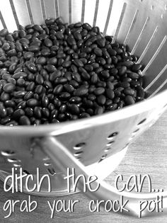 a colander filled with black beans sitting on top of a wooden table next to a quote