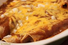 an enchilada dish with cheese and onions in a casserole dish