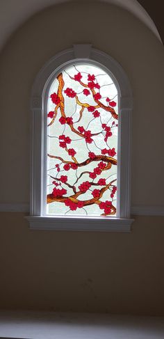 a stained glass window with red flowers on it