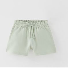 Plush Shorts With Elastic Waistband And Front Drawstring. Back Patch Pocket. Basic Summer Shorts With Elastic Waistband, Basic Elastic Waistband Shorts For Summer, Cute Cotton Shorts In Solid Color, Summer Playwear Shorts With Elastic Fit, Elastic Shorts For Summer Playwear, Summer Elastic Shorts For Playwear, Green Shorts With Built-in Shorts For Playwear, Cute Elastic Bottoms For Summer, Cute Elastic Summer Bottoms