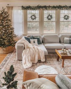 a living room filled with furniture and a christmas tree in front of a window on top of a rug