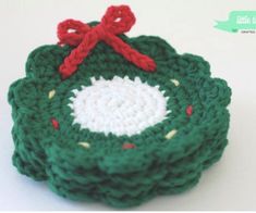 a crocheted christmas ornament with a red bow on it's end