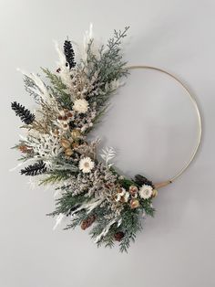 a wreath with white flowers and pine cones