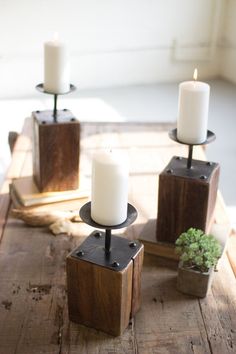 three candles sitting on top of wooden blocks