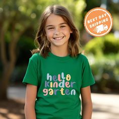 Welcome your little one to a new adventure with the Hello Kindergarten School Shirt. These unisex kindergarten shirts are perfect for the First Day of School, offering a fun and stylish way to celebrate this big milestone. Whether for preschool or kindergarten, this Back to School Shirt is designed to make them feel excited and confident. Ideal as a Kids Gift, this shirt is a wonderful way to mark the start of their educational journey. ✨ F E A T U R E S ✨ 👕 Tailored fit with vibrant colors tha Playful T-shirt For Back To School, Playful Funny Print T-shirt For School, Playful Green Top For School, Playful Green Tops For School, Cotton Tops For Playtime And Back To School, Cotton T-shirt For End Of School Year Playtime, End Of School Year Playtime Cotton T-shirt, Green Letter Print T-shirt For Playtime, Cotton Tops For School Spirit Playtime