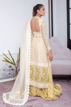 This festive silhouette is cut from cotton net in a refreshing lemon and is detailed with gota and floral embellishments. The look is completed with an organza chatta-pati dupatta with hues of lavender, teal and blush pink with triangular gota finishing and a gold brocade izaar. A piece that is a timeless wardrobe clas Yellow Organza Set With Intricate Embroidery, Yellow Organza Sets With Intricate Embroidery, Gold Chinon Lawn Suit For Wedding, Unstitched Yellow Salwar Kameez With Intricate Embroidery, Yellow Anarkali Lawn Suit With Intricate Embroidery, Yellow Organza Lehenga With Intricate Embroidery, Yellow Organza Sharara With Intricate Embroidery, Festive Beige Set With Sheer Dupatta, Beige Festive Set With Sheer Dupatta