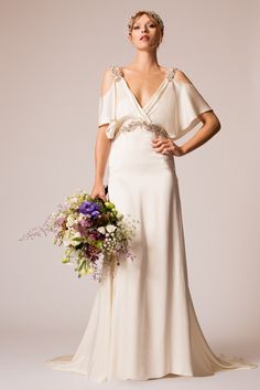 a woman in a wedding dress holding a bouquet